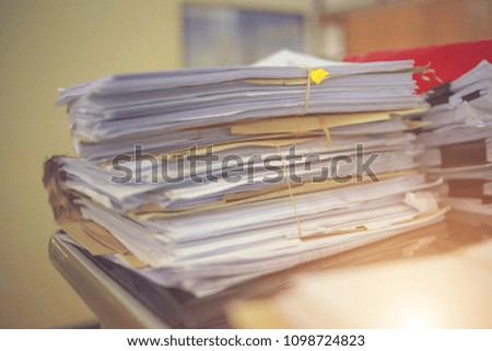 Paperwork business and file documents of unfinished stacked on office desk archive, in archive analyzing the market, and considers the size of future profits on table office. Concept work in office.