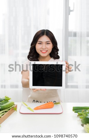 Picture of young asian woman with tablet in kitchen