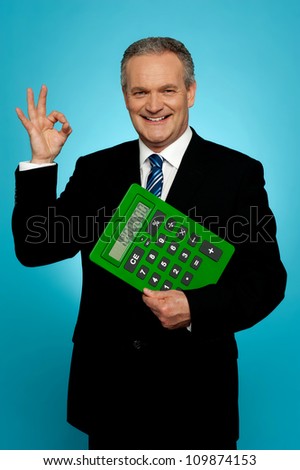 Confident executive holding calculator and gesturing okay sign isolated over gradient background