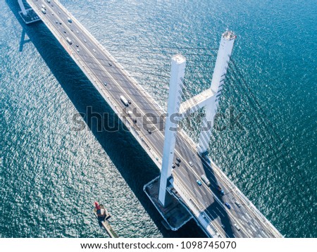 Aerial shooting of a bridge over the ocean. Top view.