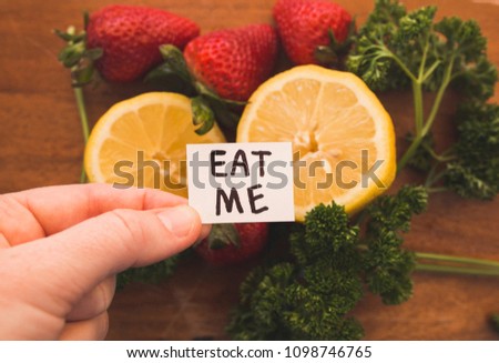 Eat Me sign over fresh fruits and veggies