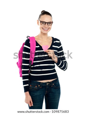 College girl showing pink paper heart to camera isolated over white