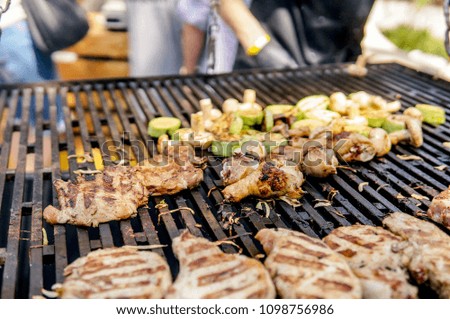 Meat with vegetables grilling over coals outdoors while celebration holiday