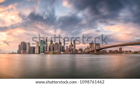 New York, New York, USA skyline of Manhattan on the East River with Brooklyn Bridge a dusk.