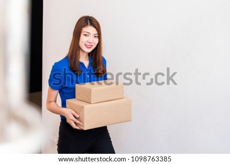 Advertising, Business, Transportation Concept - The best delivery service. Beautiful Delivery asian woman in blue uniform holding cardboard box and leave space for adding your content.  
