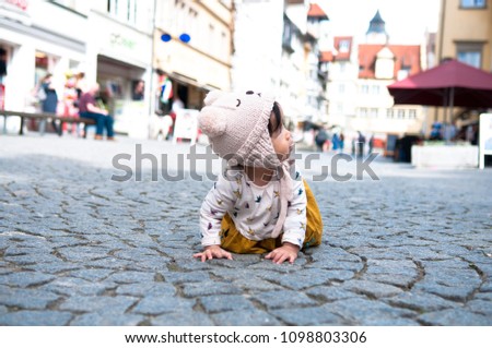 Cute baby girl is playing in central of Lindua city in the morning, Lindua, Bavaria, Germany. Baby girl in winter suit.