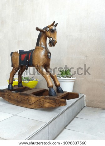 Wooden playground horse on a concrete background
