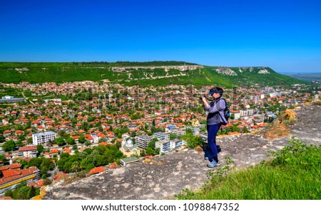 Young lady taking beautiful landscape pictures in the nature