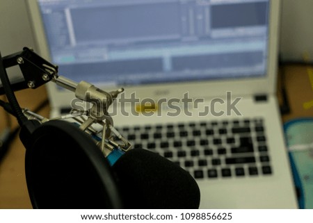 professional condenser studio microphone over editing program blurred background