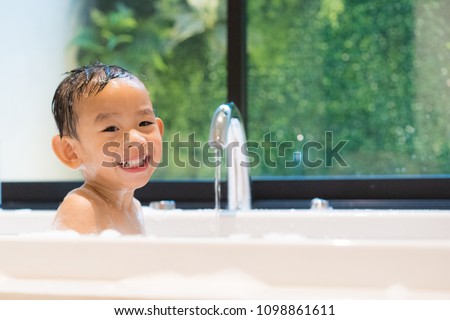 Happy bath time, Asian boy take a bath in white bathtub. Adorable little boy smiling while take a bath in beautiful bathroom. Concept for healthcare and daily routine. Royalty-Free Stock Photo #1098861611