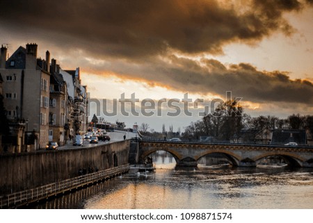 Moselle river flowing through Metz, France with a dramatic sky