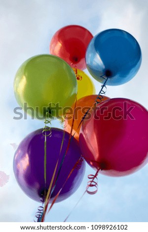 Multicoloured helium balloons in sky 