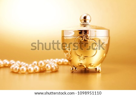 gold jewelry box gold background and pearls Royalty-Free Stock Photo #1098951110
