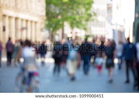 Blurred abstract people crowd background, unrecognizable silhouettes walking on a city street in a busy hour. Business concept.