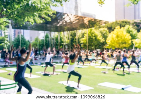 Vintage blurred rear view diverse group of people participating free public Yoga class at urban park. Outdoor Yoga training class on grass at summer day in Dallas, Texas, US, healthy lifestyle concept