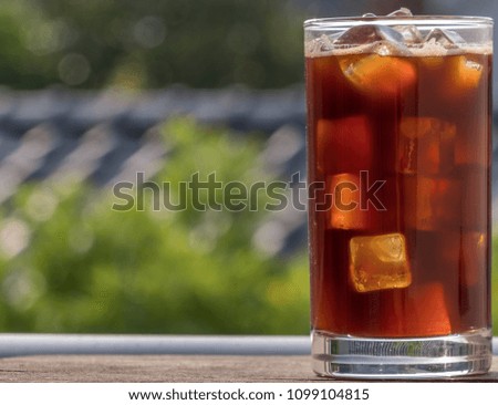 Iced coffee in a glass on wooden board