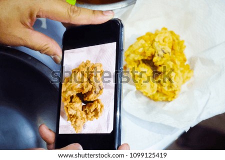 A woman holds a phone to take a photos.In the kitchen.Food photography