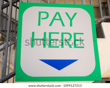 Closeup to a Pay Here sign