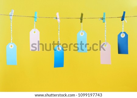 On the rope, with crumpled colored clothespins, they hang around in the puffs. A place for an inscription, mock up. An unusual photo on a yellow background.