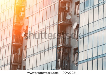 Modern high-rise business office building with a glass facade, sunny day.