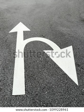 white arrow sign on the road