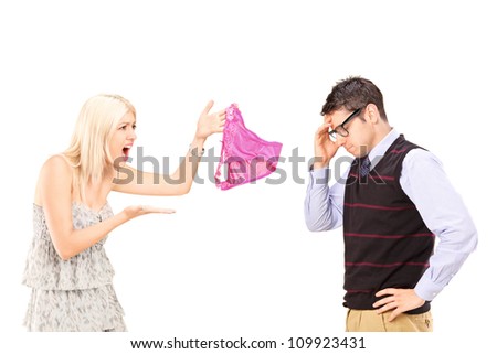 Angry girlfriend shouting at her boyfriend and holding female knickers isolated on white background Royalty-Free Stock Photo #109923431
