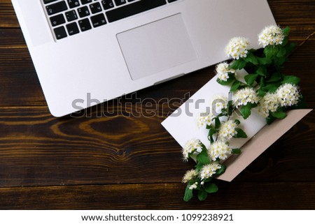 Flatlay with laptop and flowers on ol vintage wooden table
