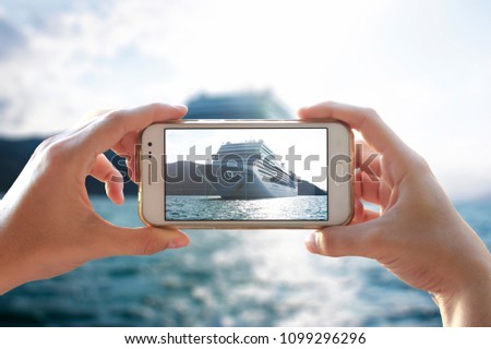 Photo camera of a smartphone. Young woman takes a photo of a cruiser. 