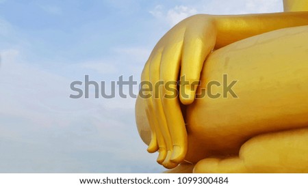 Big buddha's golden hand against beautiful blue sky at Wat Muang, Ang Thong, Thailand.