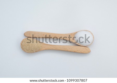 White and brown sugar in wooden spoon, isolated in white background, flat lay