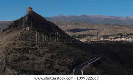 View towards north with random clouds creating shaded patches, the mountain road passing by, from the popular viewpoint El Mirador de Centinela, in San Miguel de Abona, Tenerife, Canary Islands, Spain