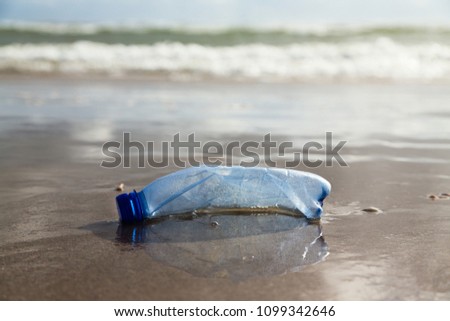 plastic bottle on the shore Royalty-Free Stock Photo #1099342646