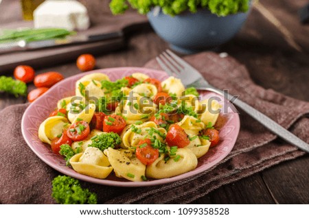 Filled tortellini with herbs, tomatoes, fresh cheese, food photography, product photo