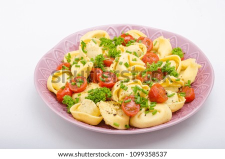 Filled tortellini with herbs, tomatoes, fresh cheese, food photography, product photo
