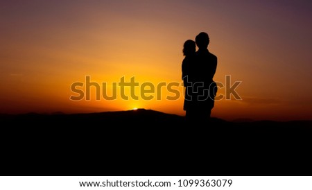 Couple woman man hugs tightly at colorful beautiful sunset with horizon in the background - concept love young romance embrance nature silhouette for ever marriage people old mood feelings holiday 
