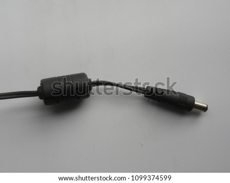 Black color male jack and ferrite bead conductor of power plug adapter on white background