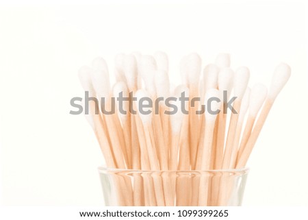 Cotton swabs standing in a glass on a white background