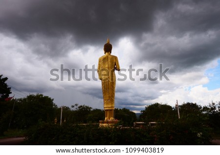 Statue of Buddha with rainy sky at Wat Phrabuddhabat Khao Phrik, Amphoe Sikhiu, Nakhon Ratchasima province, Thailand.