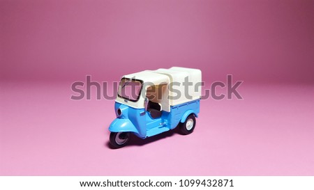 Front side of Tuk tuk or blue vehicle on pink background