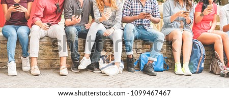 Happy millennials friends surfing online with mobile phones - Young people using smartphone outdoor - Youth lifestyle, generation z and technology trend concept - Focus on hands mobiles Royalty-Free Stock Photo #1099467467