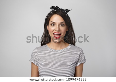 Success, victory and achievement concept. Picture of beautiful emotional young brunette woman expressing full disbelief, opening mouth widely in amazement, shocked after boss raised her salary