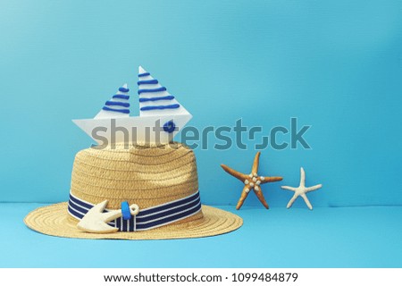Hat and a paper boat on a wooden surface