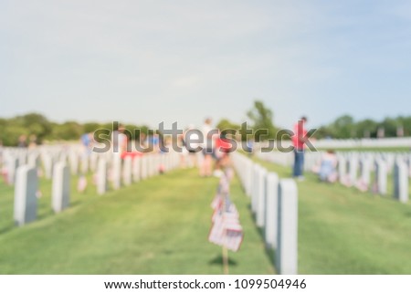 Blurred motion volunteers, family members place flags in front of each fallen heroes headstone. Memorial day celebration, honoring the legacy veterans Dallas–Fort Worth National Cemetery, USA