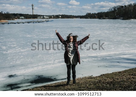 Cheerful young woman enjoying her holidays in Stockholm, Sweden. Taking some photos on a sunny and cold spring day. Lifestyle photography.