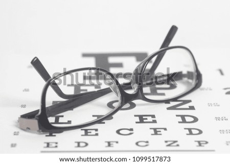 Eyeglasses on eyesight test chart background