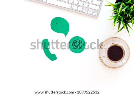 Contact us concept. Phone, message and email signs on office work desk with computer on white background top view copy space