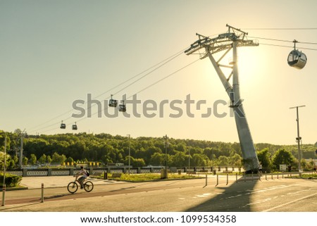 Urban new cable car in Luzhniki park, Moscow, Russia. Cableway cabins hang over Moskva River between Sparrow Hills and Luzhniki Stadium in summer. Scenic sunny view of Luzhniki Embankment in Moscow. Royalty-Free Stock Photo #1099534358