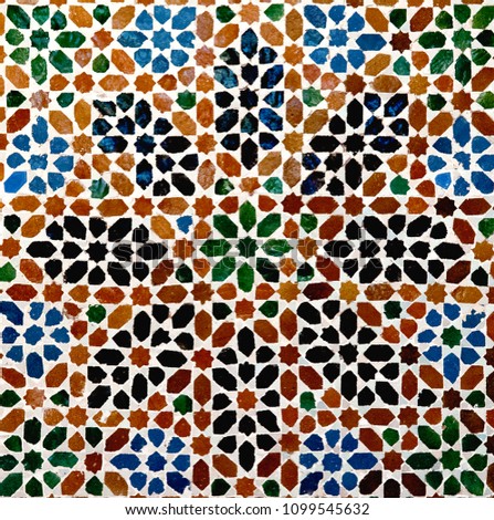 The colorful geometric patterns of an Islamic mosaic decorate the Alhambra Palace in Granada, Spain.