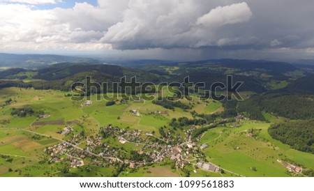 Aereal droneshot of countryside with stormclouds. Bretzwil Switzerland