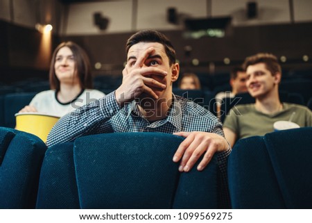 Scared man watching movie in cinema